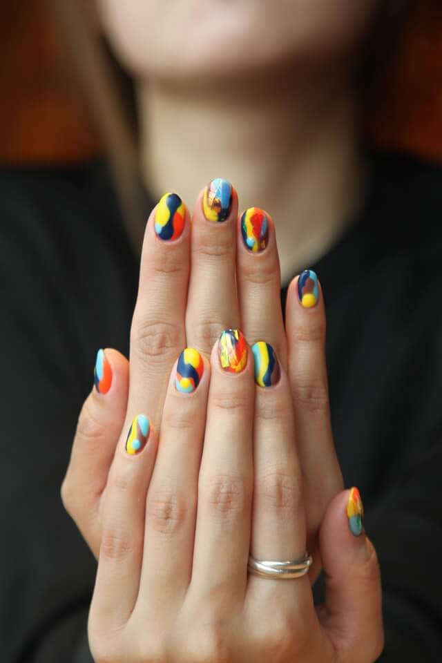 A woman showing her nail's manicure at home.