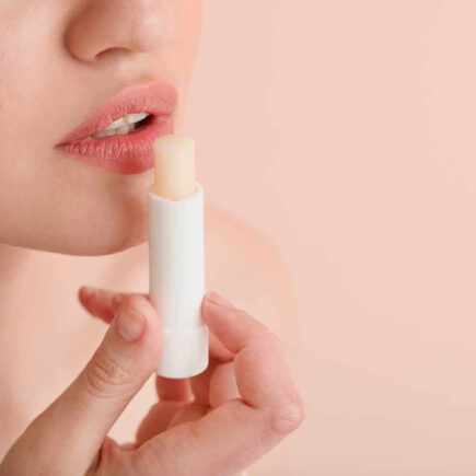 Close-up of a woman applying Chapstick