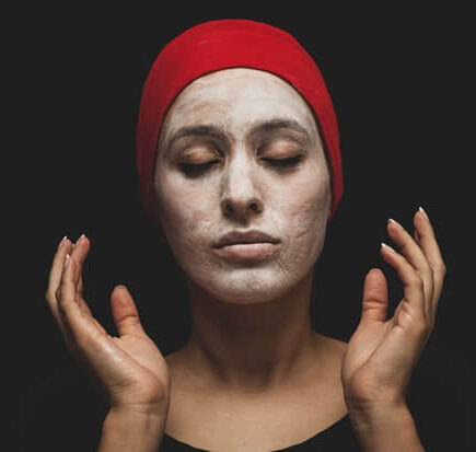 A woman applying Face Scrub on her face.