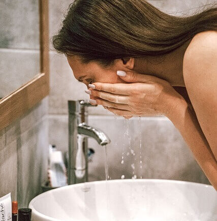 A lady washing her face