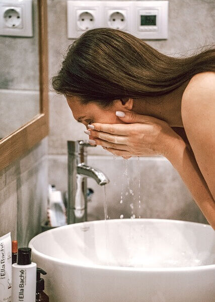 A lady washing her face